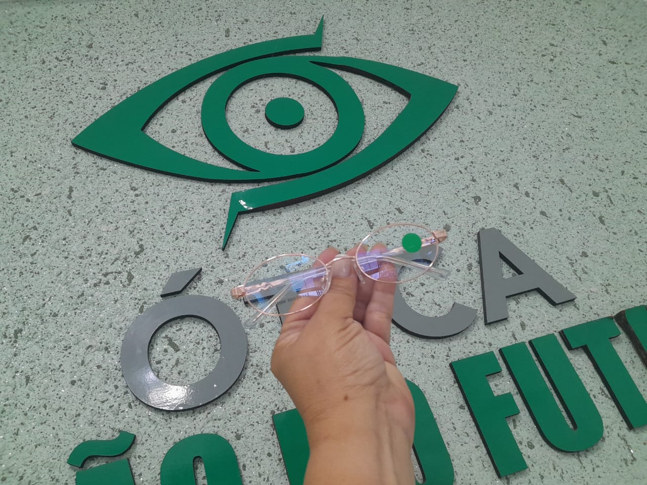 Armação de óculos em destaque diante da identidade visual da ótica